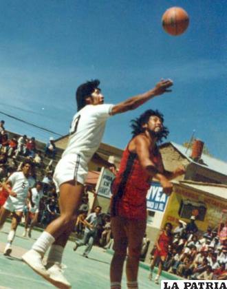 En una acción de juegos, René Callejas intenta encestar ante la marca de su adversario, el partido se jugó en la cancha oficial de la calle La Paz en 1969