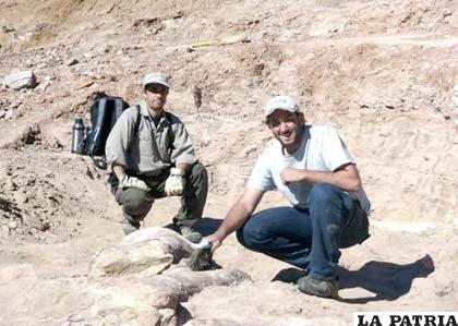 Expertos posando junto a fósiles de un dinosaurio, a unos 1.300 km al sur de Buenos Aires