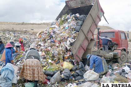 Varias personas buscan residuos sólidos entre la basura