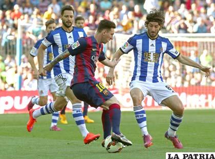 Messi controla el balón frente a dos defensas del Valencia