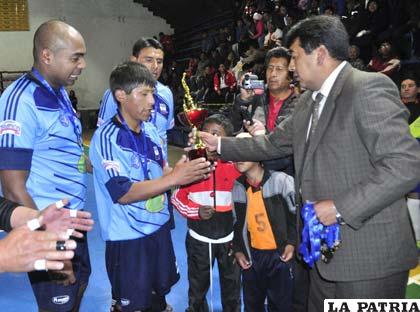 Hugo Paco entrega el trofeo a Juan Carlos Gutiérrez  (Saavedra tercero)