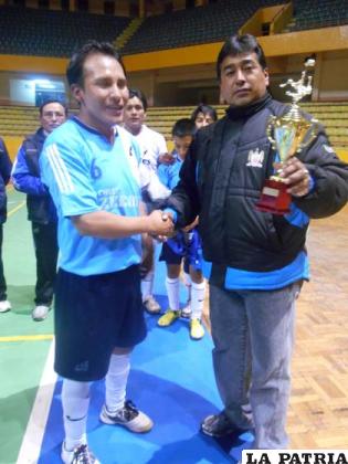 Flores, de Real Norte, recibe el trofeo de campeón