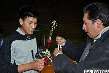 Ramallo, capitán de Carl A-Z, recibe el trofeo de manos de Flores