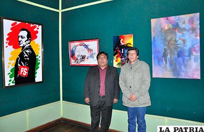 Maclovio Marconi (izq.) y Grover Padilla (der.) con parte de las pinturas en exhibición