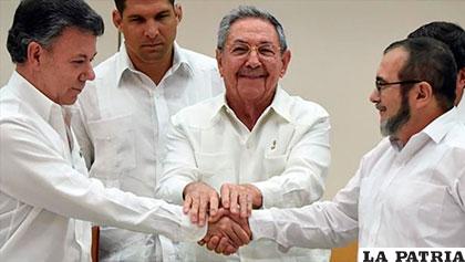 El presidente colombiano, Juan Manuel Santos (izq), el ex presidente de Cuba, Raúl Castro (centro), y Timoleon Jiménez, jefe negociador de las FARC