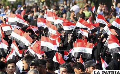Partidarios del clérigo chií Muqtada al Sadr, ondean banderas nacionales durante una manifestación