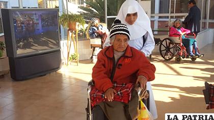 Una religiosa traslada a una anciana en el Hogar San Ramón /ANF