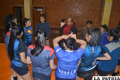 El entrenador Ronald Ríos dialoga con las deportistas al final del entrenamiento /Alex Zambrana - LA PATRIA