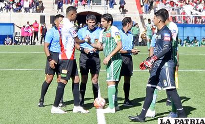 El árbitro Hurtado observa el saludo de los capitanes en lo que fue su último partido /APG