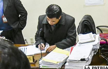Una foto de archivo en la que se ve al juez Huacani firmar documentos /APG
