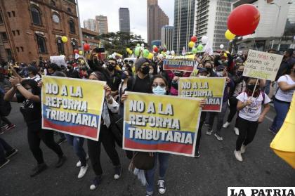 Manifestantes sostienen carteles que dicen en español “No a la reforma tributaria” /AP Foto/Fernando Vergara