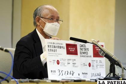 El abogado Kenji Utsunomiya, representante de un grupo anti-Juegos Olímpicos, muestra tableros con la cifra actual de firmas de un petitorio online (AP Foto/Eugene Hoshiko)
