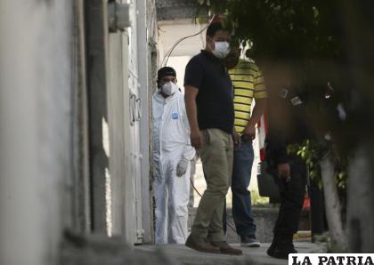 Un investigador forense permanece en la entrada de una vivienda donde la policía encontró restos óseos enterrados  /AP Foto/Fernando Llano