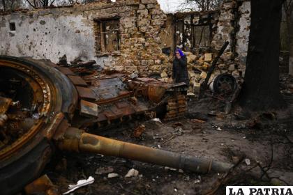 Valentyna Sherba, de 68 años, está junto a un tanque ruso en el patio trasero de la casa de su padre, ambos destruidos / AP Foto / Francisco Seco