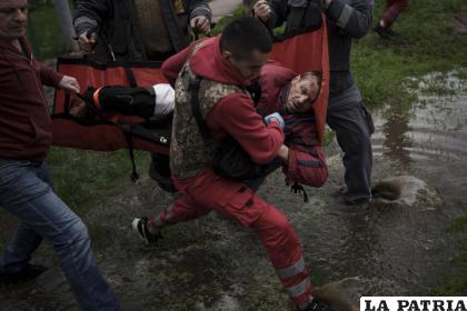Los habitantes de la localidad ayudan a un trabajador de emergencias a llevar a una ambulancia, a un hombre herido al que le falta parte de una pierna 
/ AP Foto / Felipe Dana