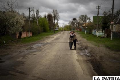 Tetyana Boikiv, de 52 años, a la derecha, abraza a su vecina Svitlana Pryimachenko, de 48 años, durante el funeral de su marido  / AP Foto / Emilio Morenatti