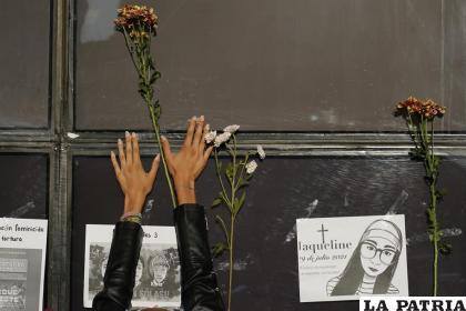 Una mujer coloca flores en la fachada de la Fiscalía General de la República durante una protesta por la desaparición de Debanhi Escobar /  AP Foto / Eduardo Verdugo