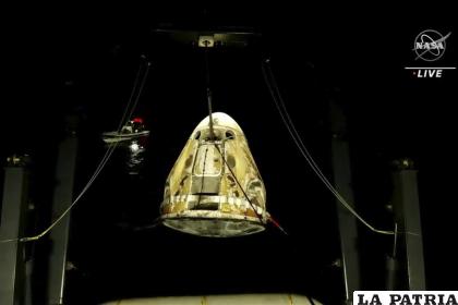 En esta imagen de un video distribuido por la NASA, alzan la cápsula espacial SpaceX Dragon de aguas del Golfo de México