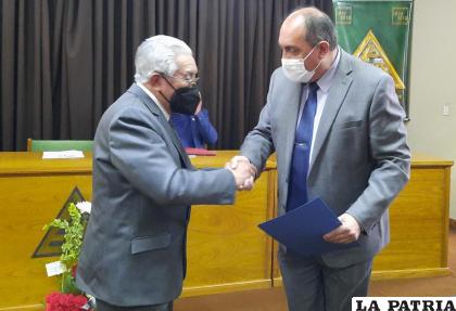 El presidente de la APO, José Luis Zabalaga entrega el reconocimiento a LA PATRIA, representado por su gerente, Marcelo Miralles /LA PATRIA