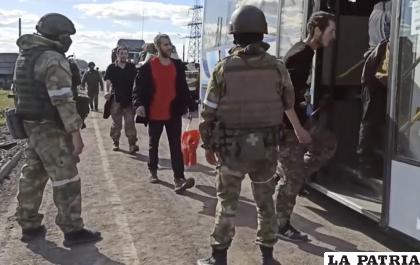 Soldados rusos observan a combatientes ucranianos evacuados de la acería Azovstal en Mariúpol, Ucrania /Servicio de Prensa del Ministerio de Defensa de Rusia via AP