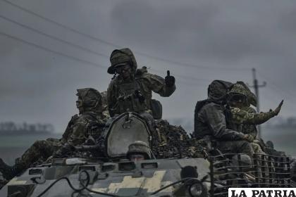 Soldados ucranianos en un vehículo artillado rumbo a sus posiciones en el frente de batalla /AP Foto/Libkos