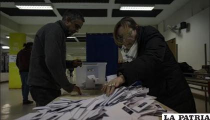 Los trabajadores electorales cuentan las papeletas después del cierre de las urnas /AP