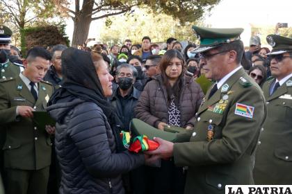 El Comandante Ríos (derecha) entrega la bandera y gorra armada a la esposa del uniformado /LA PATRIA
