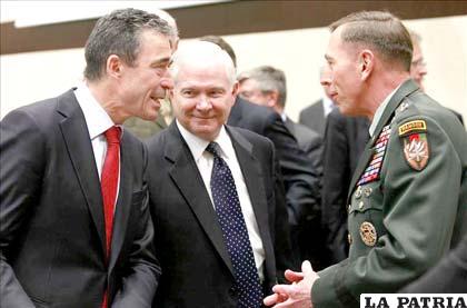 El secretario general de la OTAN, Anders Fogh Rasmussen (i), conversa con el comandante de la misión militar de la OTAN, David Petraeus