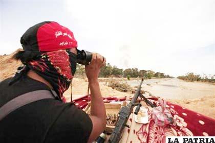 En la imagen, un combatiente rebelde mira a través de unos prismáticos una explosión en Misrata