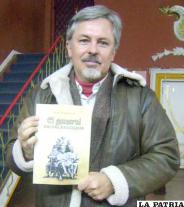 Robert Brockman, mostrando su libro en el que resume la vida y trabajo realizado por el General Hans Kundt