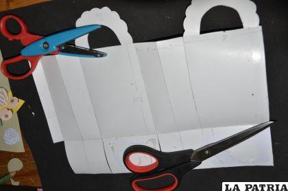 PASO 5
Para la bolsa cortar según el molde la cartulina texturada blanca como indica en la fotografía y pegar primero el costado y luego la parte de abajo.
