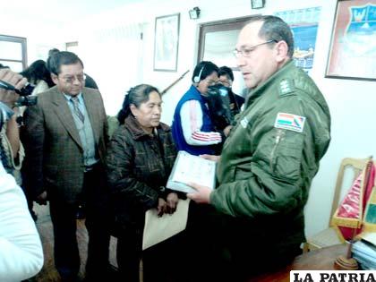 El director de la Felcc, entrega los anillos a la propietaria de la Joyería Asunción