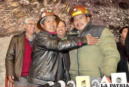 Los dirigentes de ambos sectores se dan la mano en son de paz, ante la mirada de los ministros involucrados