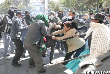 Policías quitaron a los campesinos afines al MAS sus ponchos y los quemaron, luego los desalojaron de la plaza Murillo (Foto APG)
