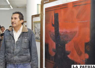 Ganador del primer premio en óleo, Augusto Navarro junto a su obra