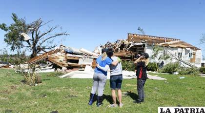 Familia observa los restos de su casa tras el paso de un tornado en El Reno, Oklahoma (EE.UU.)