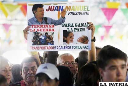 Un hombre sostiene una pancarta en apoyo al presidente de Colombia y candidato a la reelección Juan Manuel Santos