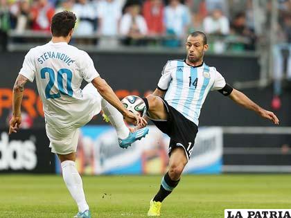 Stevanovic y Mascherano disputan el balón
