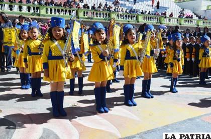 Las niñas de la banda de guerra del Jardín Óscar Alfaro, cantan con emoción el himno de su establecimiento