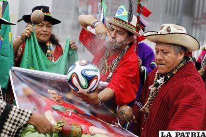 Sujetando el balón y un poster de Cristiano Ronaldo, estos chamanes esperan alejar la mala suerte del torneo