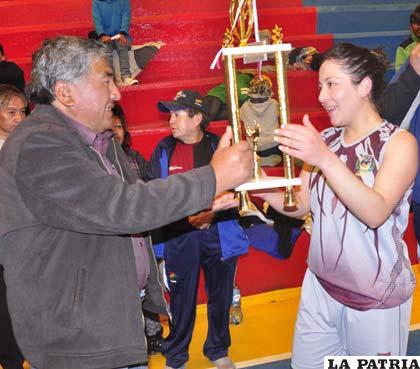 Etzhel Llanque, hace la entrega del trofeo de campeón a Cinthia Morejón