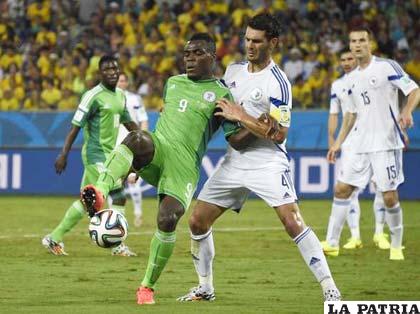 Emenike (Nigeria) disputa el balón con Spahic (Bosnia)