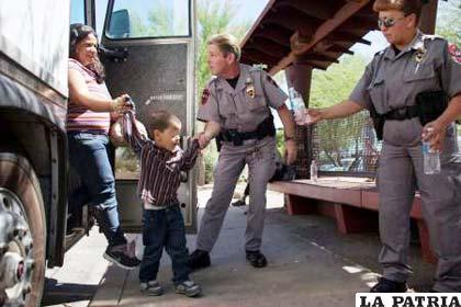 Policía fronterizo jalonea a un niño que baja del bus con su madre