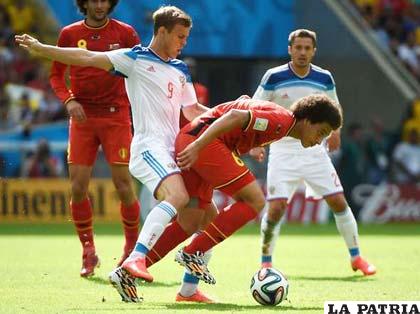 Kakorin (Rusia) intenta arrebatarle la pelota a Witsel de Bélgica
