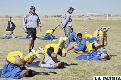 El médico Callejas y el asistente técnico José Peña, observan el trabajo de los jugadores