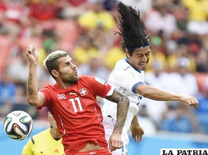 Behrami de Suiza y Espinoza de Honduras disputan la pelota 