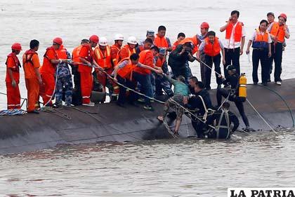 Rescatistas ayudan a un superviviente tras el naufragio