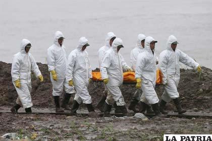 Miembros de un grupo de rescate transporta el cuerpo de una persona fallecida en la tragedia del barco Estrella Oriental en el río Yangtsé (China)