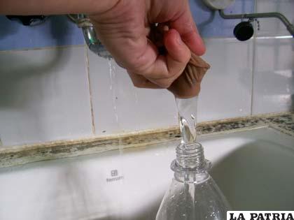 4.- Llena la botella hasta sus ¾ partes, y comprímela para que el agua llegue al tope.