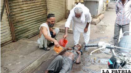 Vecinos de Karachi, ayudan a un anciano que se desmayó por falta de agua /cubadebate.cu